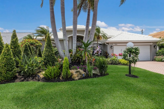 3806 72nd Ter E, Sarasota, FL 34243 - mediterranean / spanish-style house featuring a garage, stucco siding, a tile roof, a front lawn, and driveway