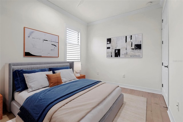 bedroom with crown molding, light wood-type flooring, and baseboards
