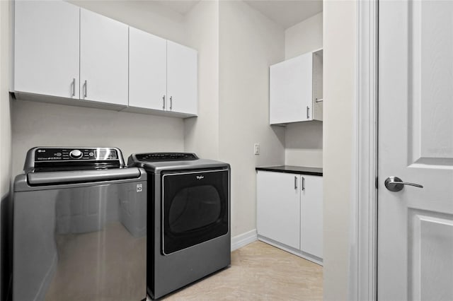 laundry room featuring cabinet space, washing machine and clothes dryer, and baseboards