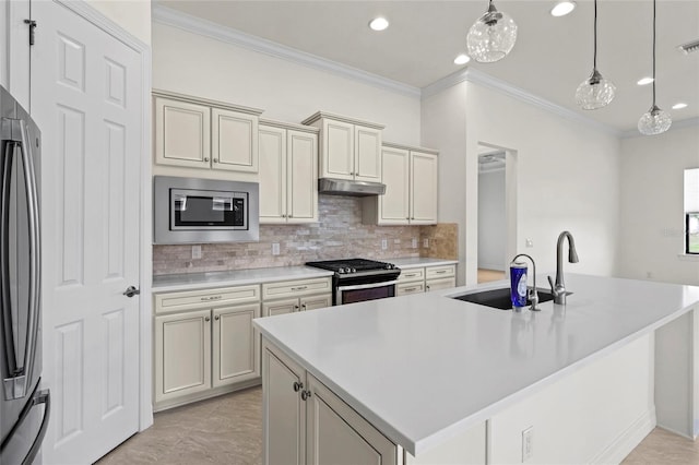 kitchen with stainless steel appliances, under cabinet range hood, ornamental molding, a sink, and tasteful backsplash