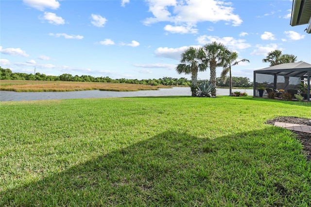 view of green lawn featuring a water view