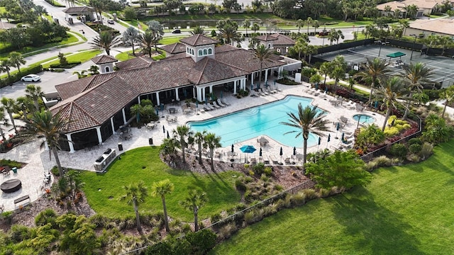 community pool featuring a lawn and a patio