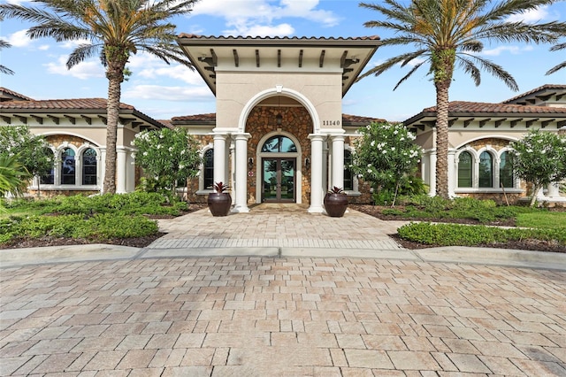 view of front of home with french doors, stucco siding, and a tiled roof