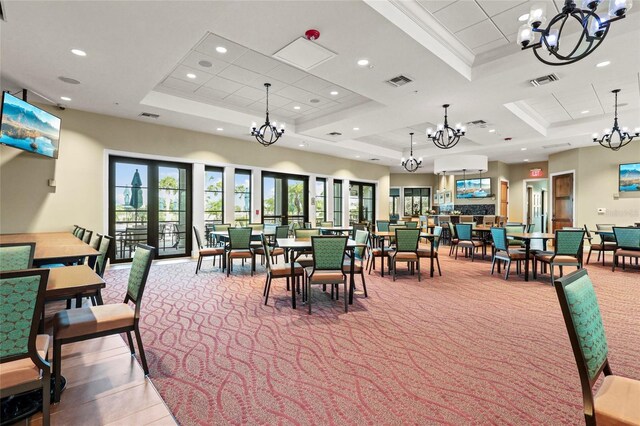 dining room featuring a tray ceiling, a chandelier, carpet flooring, recessed lighting, and crown molding