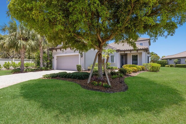 8191 Gabanna Dr, Sarasota, FL 34231 - mediterranean / spanish home with a tiled roof, stucco siding, driveway, and an attached garage