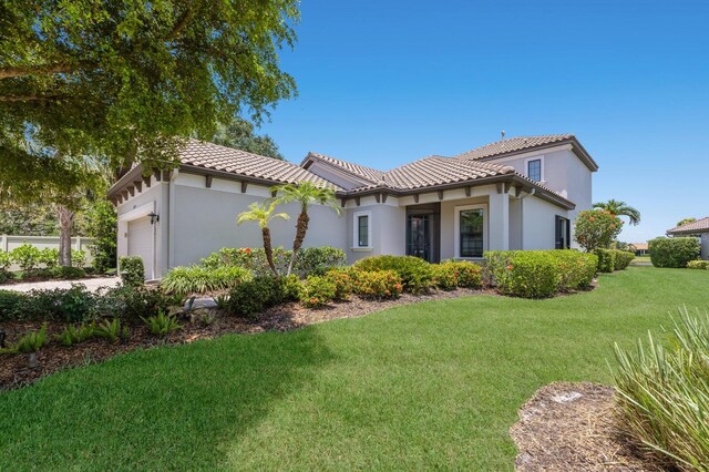 8191 Gabanna Dr, Sarasota, FL 34231 - view of front of property featuring an attached garage, a tile roof, stucco siding, and a front yard