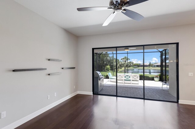 8191 Gabanna Dr, Sarasota, FL 34231 - unfurnished room with dark wood-type flooring, baseboards, a ceiling fan, and a water view