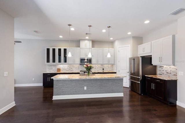 8191 Gabanna Dr, Sarasota, FL 34231 - kitchen with appliances with stainless steel finishes, backsplash, white cabinets, light stone counters, and recessed lighting