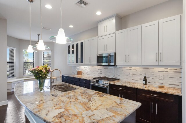 8191 Gabanna Dr, Sarasota, FL 34231 - kitchen featuring appliances with stainless steel finishes, a sink, backsplash, a center island with sink, and recessed lighting