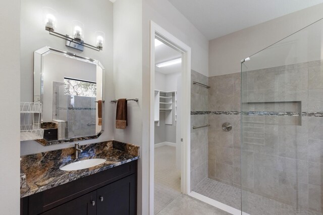 8191 Gabanna Dr, Sarasota, FL 34231 - full bathroom featuring walk in shower, vanity, a walk in closet, and tile patterned floors