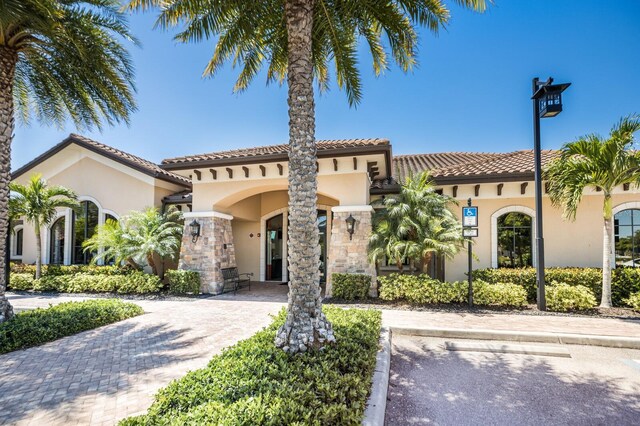 8191 Gabanna Dr, Sarasota, FL 34231 - mediterranean / spanish house with stucco siding, a tiled roof, and stone siding