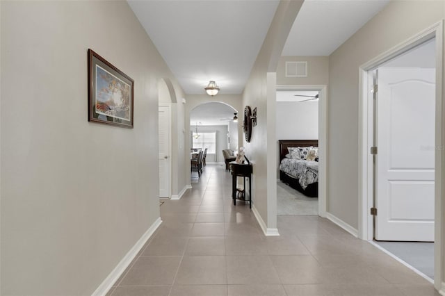 5111 11th St E, Bradenton, FL 34203 - hallway with arched walkways, light tile patterned floors, and baseboards