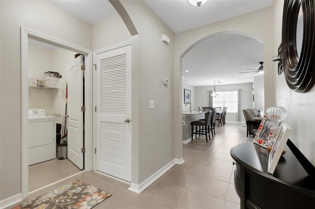 5111 11th St E, Bradenton, FL 34203 - corridor featuring washer / dryer, arched walkways, light tile patterned floors, and baseboards