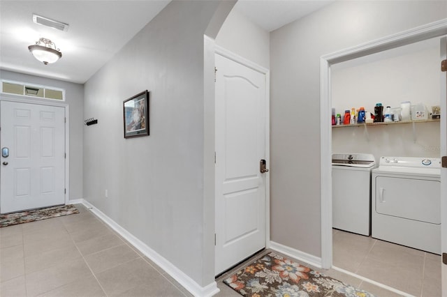 5111 11th St E, Bradenton, FL 34203 - entrance foyer featuring arched walkways, light tile patterned flooring, separate washer and dryer, and baseboards