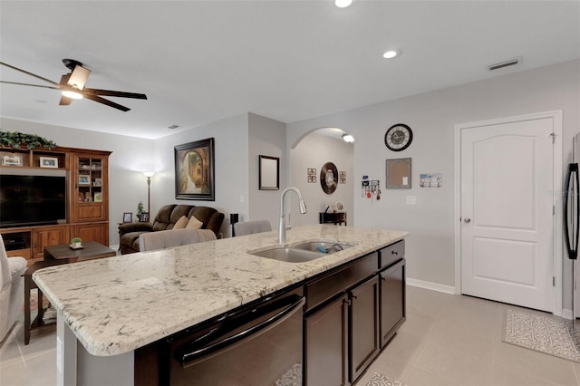 5111 11th St E, Bradenton, FL 34203 - kitchen featuring a sink, arched walkways, dishwasher, an island with sink, and light stone counters
