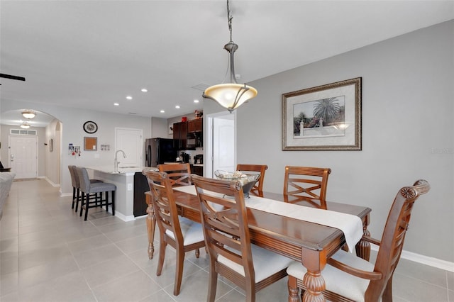 5111 11th St E, Bradenton, FL 34203 - dining space featuring arched walkways, light tile patterned floors, recessed lighting, and baseboards