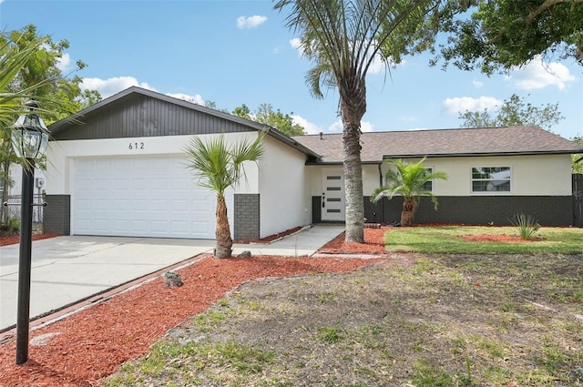 612 65th Ave W, Bradenton, FL 34207 - view of front facade featuring brick siding, concrete driveway, an attached garage, and stucco siding