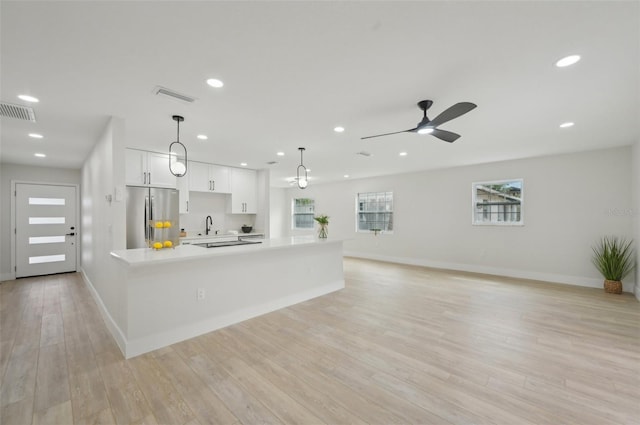 612 65th Ave W, Bradenton, FL 34207 - kitchen featuring stainless steel refrigerator with ice dispenser, light countertops, a sink, baseboards, and white cabinets