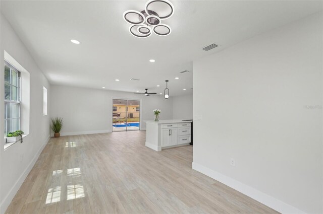 612 65th Ave W, Bradenton, FL 34207 - unfurnished living room with recessed lighting, baseboards, light wood-style flooring, ceiling fan, and a chandelier