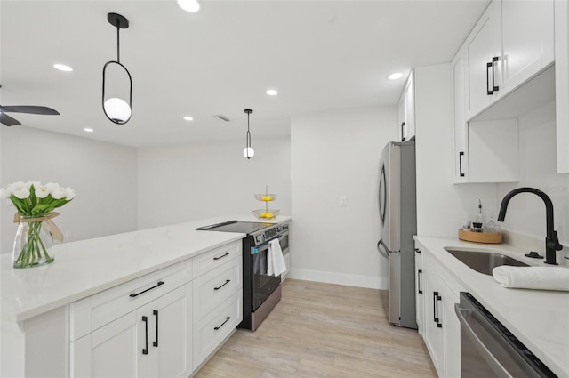 612 65th Ave W, Bradenton, FL 34207 - kitchen featuring a sink, appliances with stainless steel finishes, white cabinetry, light wood finished floors, and recessed lighting