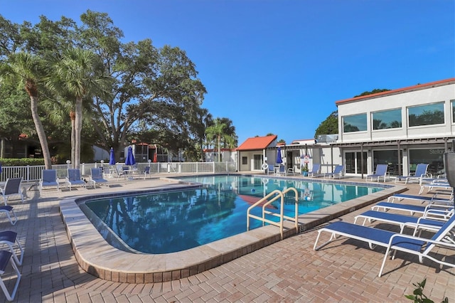 community pool with fence and a patio area