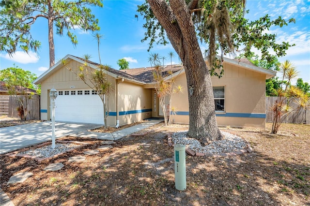 view of front of house with fence, a garage, and concrete driveway