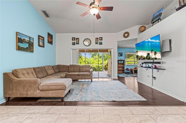 living area featuring a ceiling fan, wood finished floors, baseboards, and a textured ceiling