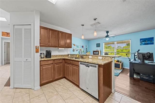 kitchen with dishwasher, a peninsula, a sink, brown cabinets, and light stone countertops