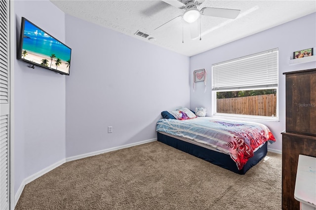 bedroom featuring carpet floors, a textured ceiling, baseboards, and a ceiling fan