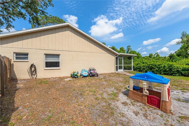 back of property with a sunroom and fence