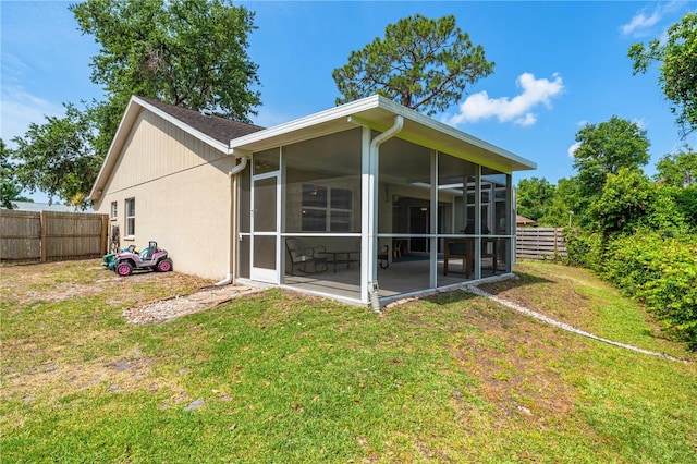 rear view of house featuring a sunroom and stucco siding