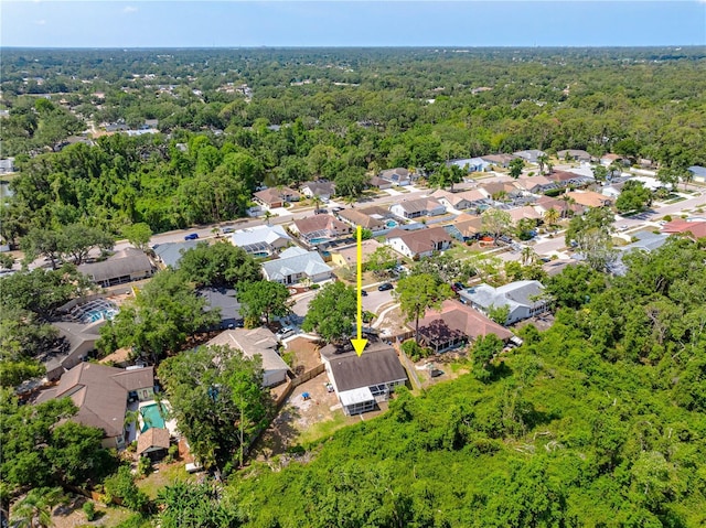 view of property location featuring a heavily wooded area and nearby suburban area