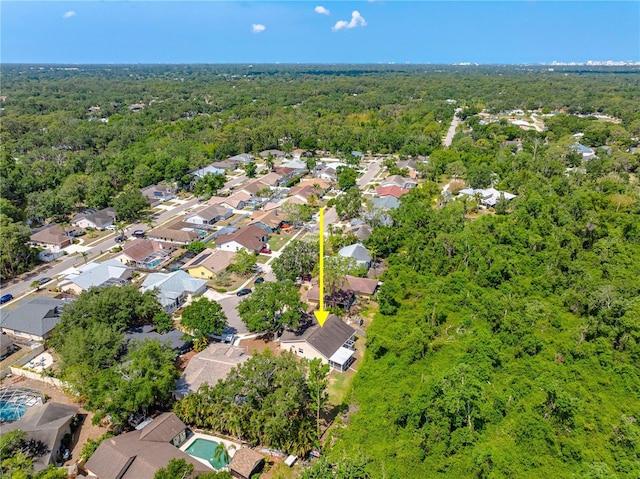 aerial overview of property's location featuring a forest and nearby suburban area
