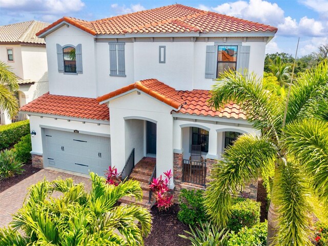 5823 Title Row Dr, Bradenton, FL 34210 - mediterranean / spanish-style house with a garage, a tile roof, decorative driveway, and stucco siding