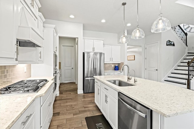 5823 Title Row Dr, Bradenton, FL 34210 - kitchen featuring appliances with stainless steel finishes, white cabinets, an island with sink, recessed lighting, and premium range hood