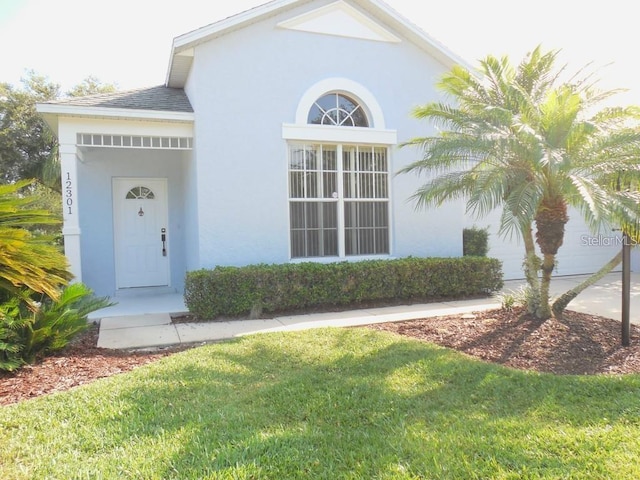 12301 Mosswood Pl, Lakewood Ranch, FL 34202 - property entrance featuring stucco siding and a yard