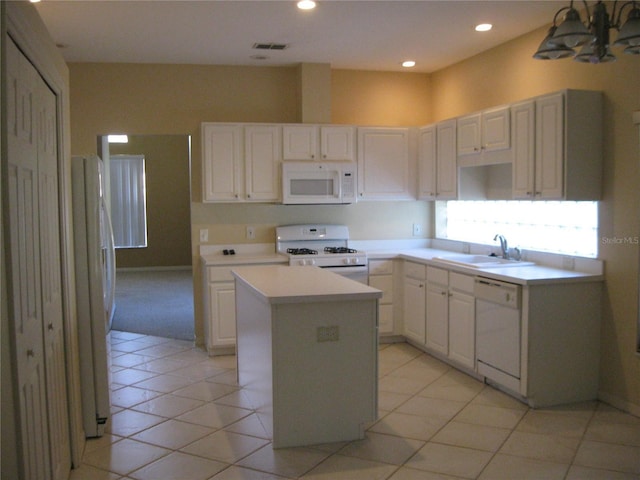 12301 Mosswood Pl, Lakewood Ranch, FL 34202 - kitchen featuring white appliances, a sink, a kitchen island, light countertops, and white cabinetry