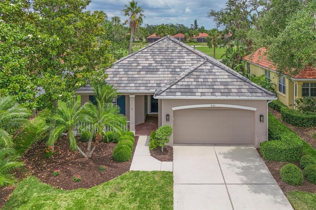 view of front of property featuring stucco siding, a garage, and driveway