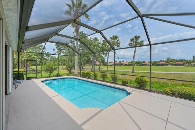 swimming pool featuring a patio area, a yard, and a lanai