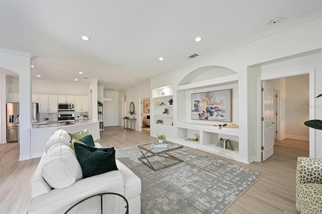 living room with crown molding, arched walkways, recessed lighting, light wood finished floors, and baseboards