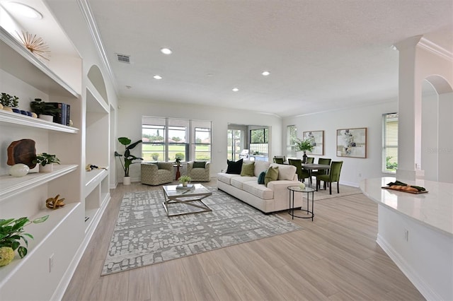 living room with light wood-type flooring, recessed lighting, baseboards, and ornamental molding