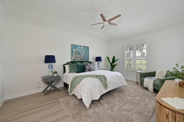bedroom featuring crown molding, light wood-style floors, baseboards, and a ceiling fan