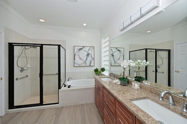 full bath with a stall shower, a garden tub, crown molding, double vanity, and recessed lighting