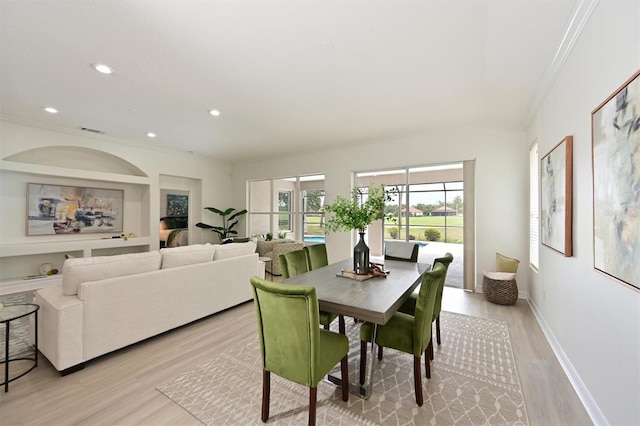 dining room with light wood-style flooring, crown molding, recessed lighting, and baseboards