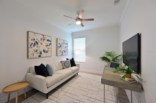 living area with ornamental molding, ceiling fan, and baseboards