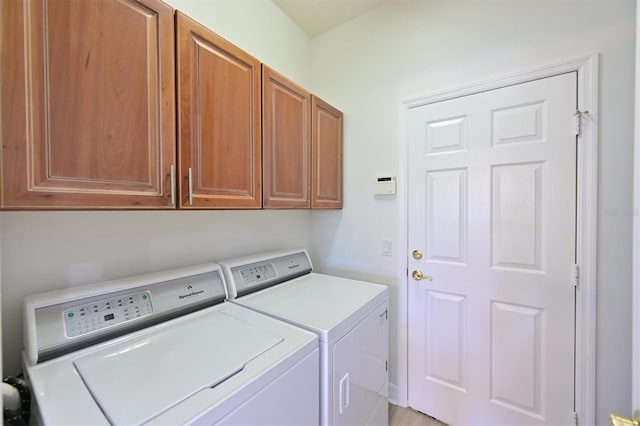 laundry room featuring separate washer and dryer and cabinet space