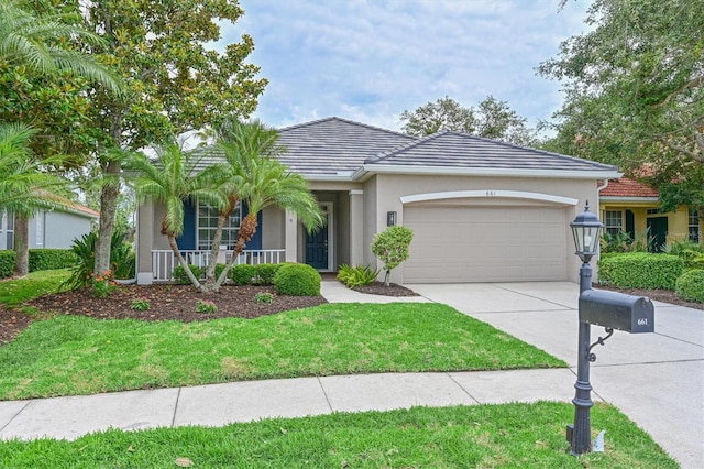 single story home with a garage, stucco siding, a porch, a front yard, and driveway
