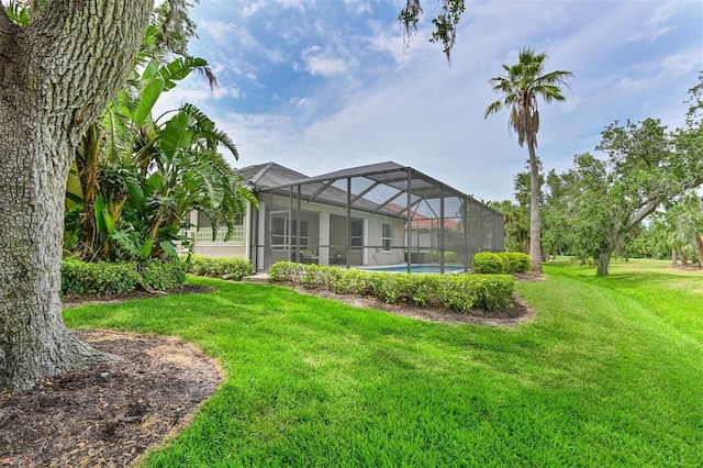 view of grassy yard featuring glass enclosure