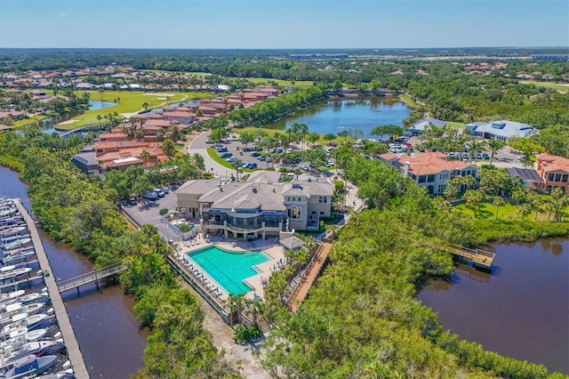 drone / aerial view of a nearby body of water and a pool