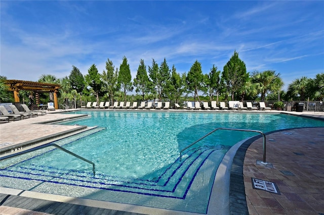 community pool with a pergola, a patio area, and fence